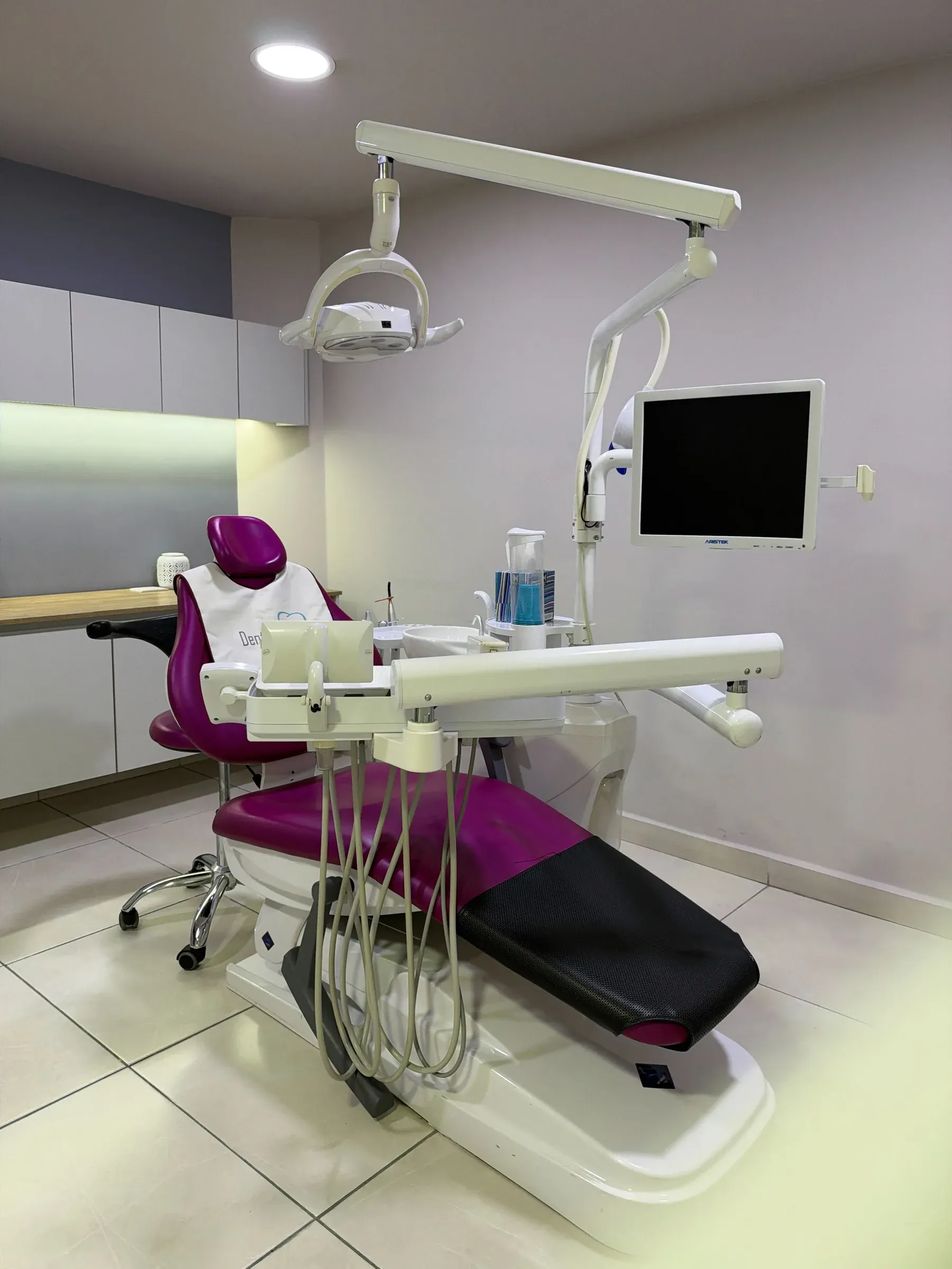 Consultorio de Dental Cast con sillón dental magenta y lámpara clínica