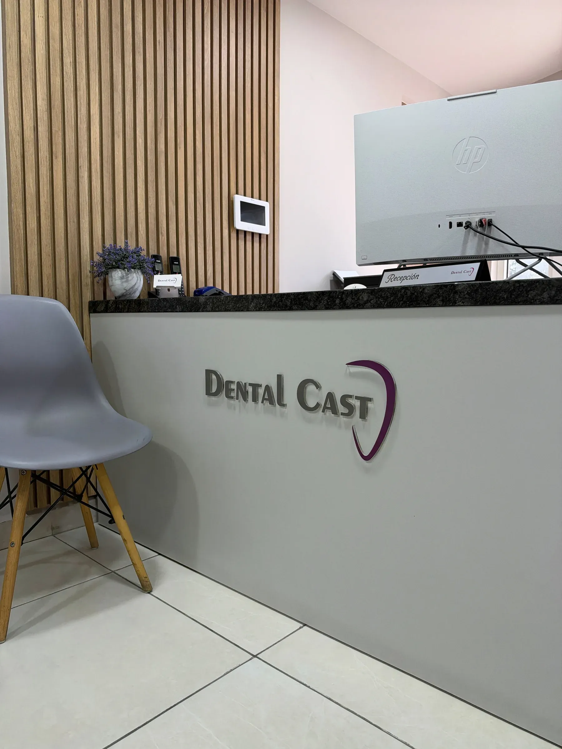 Recepción de Dental Cast con el logotipo de la clínica en el mostrador