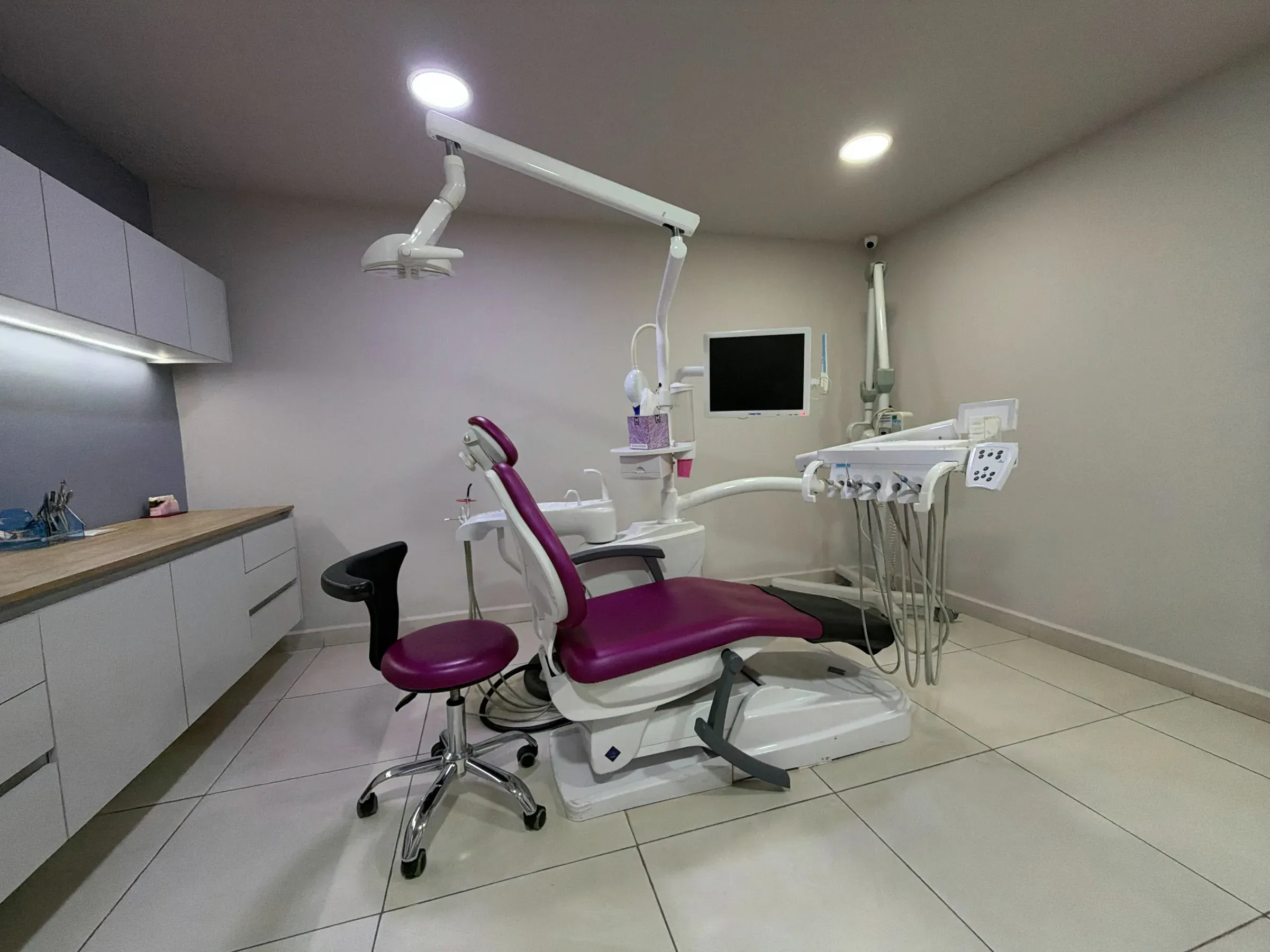 Consultorio de Dental Cast con sillón dental magenta y equipo clínico