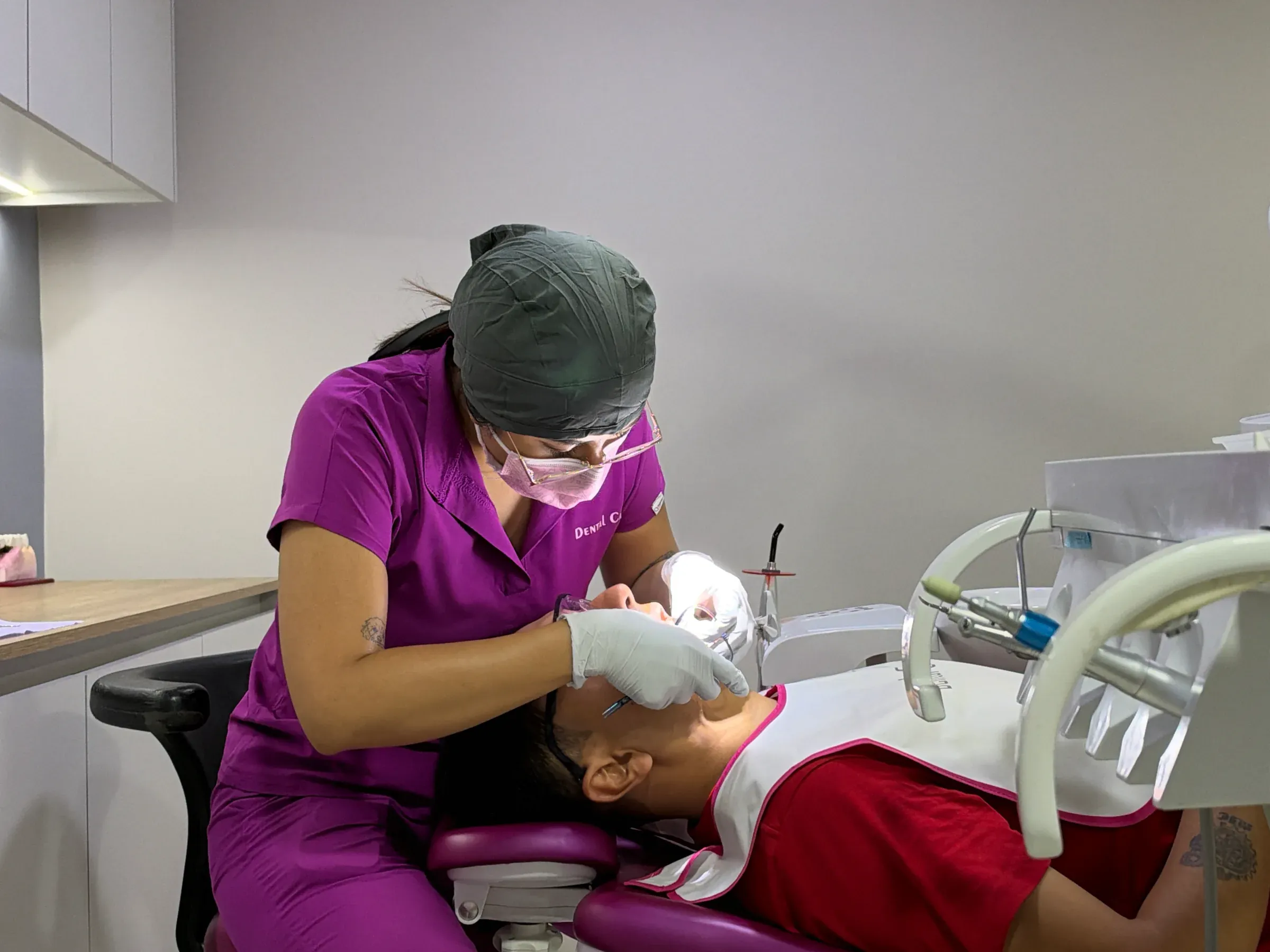 Integrante del equipo de Dental Cast revisa la boca de un paciente en el sillón dental