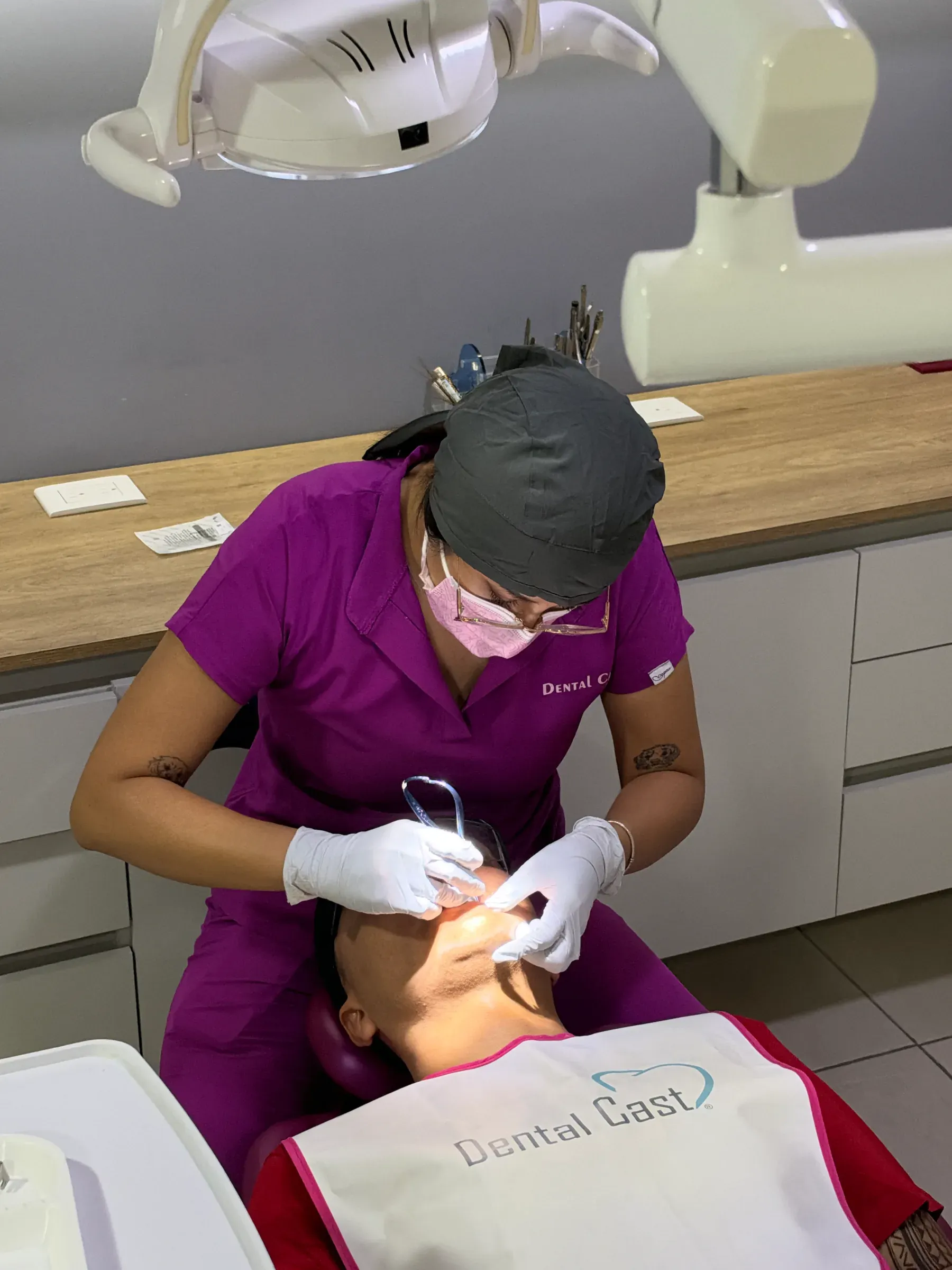 Doctora de Dental Cast atendiendo a un paciente en el sillón dental