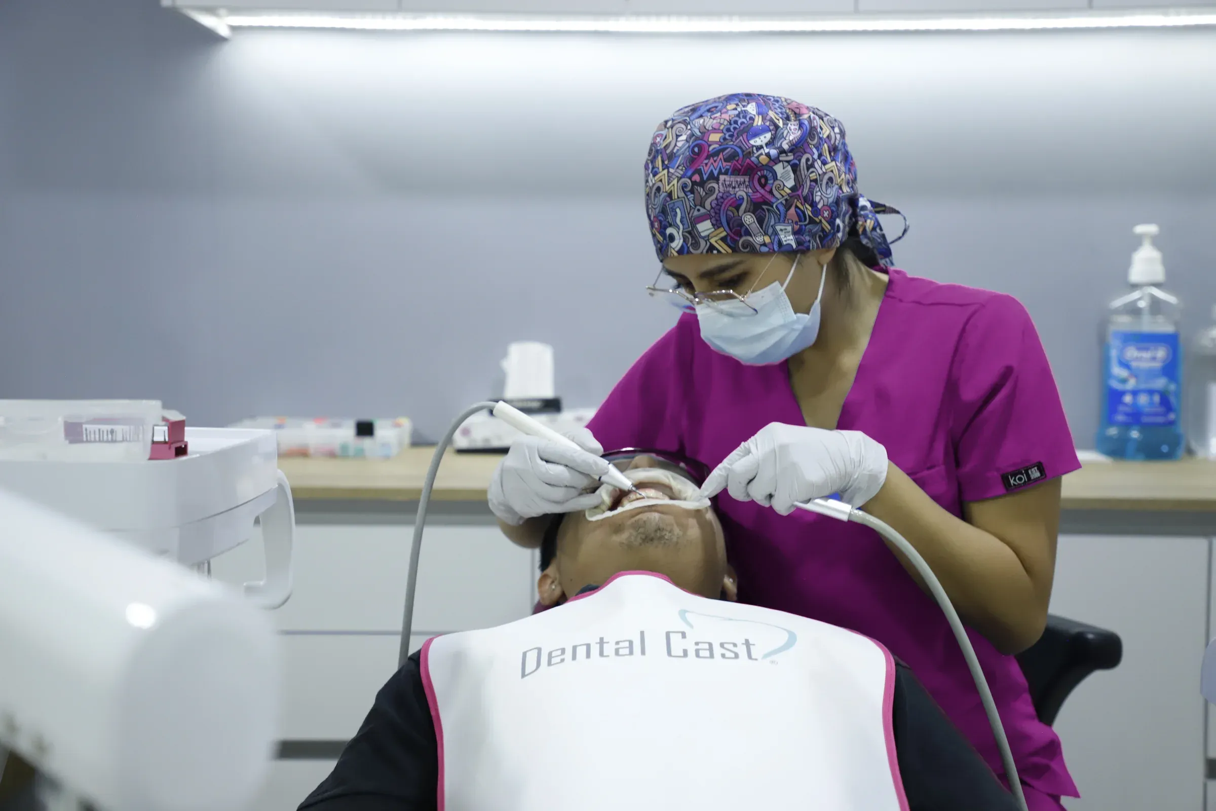 Integrante del equipo de Dental Cast hace una limpieza con ultrasonido a un paciente en el sillón